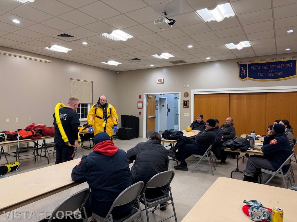 Lead Foreman Mike Peck reviewing water rescue equipment as Probationary Firefighter/EMT Candidate Jared Richardson tries on the Mustang suit - 02/09/26