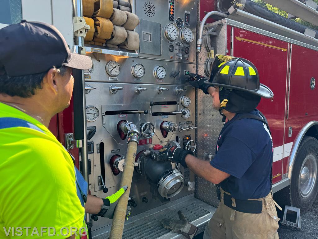 Probationary Firefighter Peter Cipriano practicing how to use the Engine 143 pump panel as Firefighter Martin Rojas looks on - 07/14/24