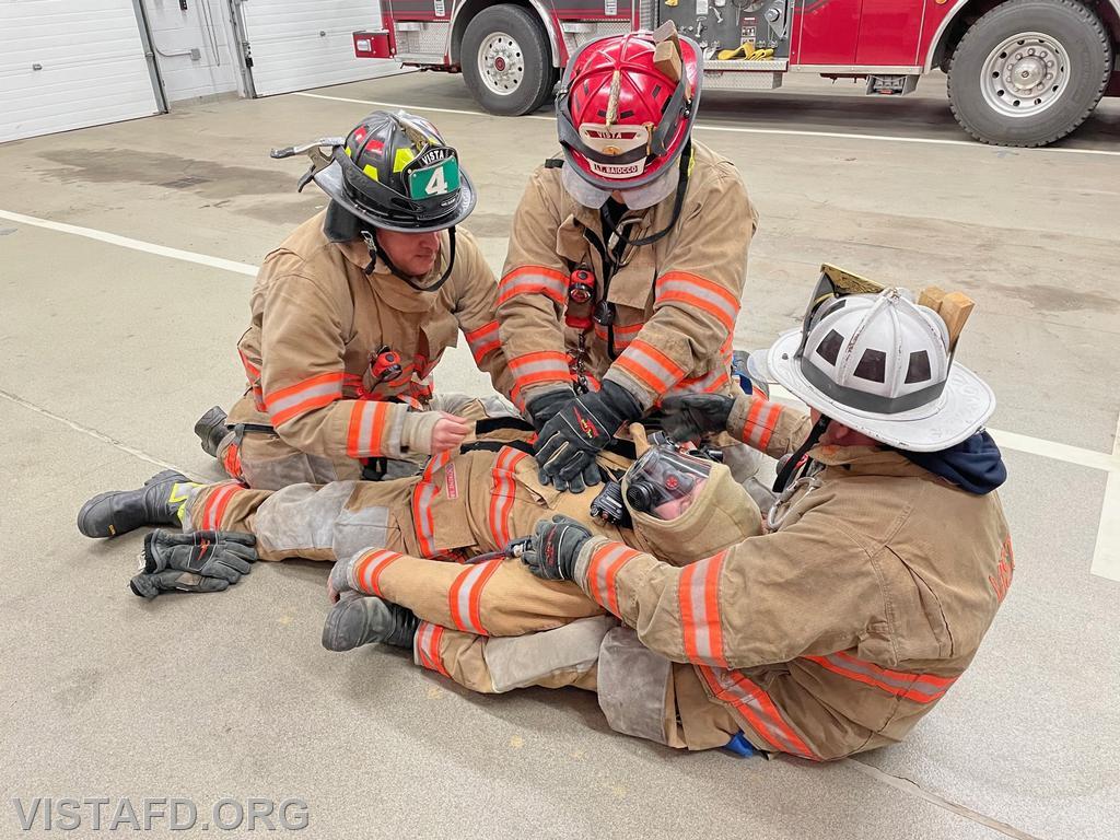 Vista Firefighters packaging a downed Firefighter while giving CPR