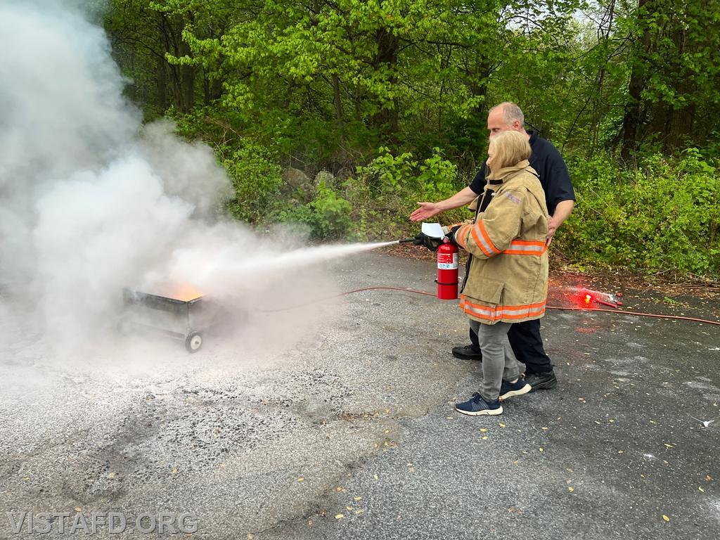 Members of the community learning how to use a fire extinguisher during the "Spaghetti Night and Open House" event