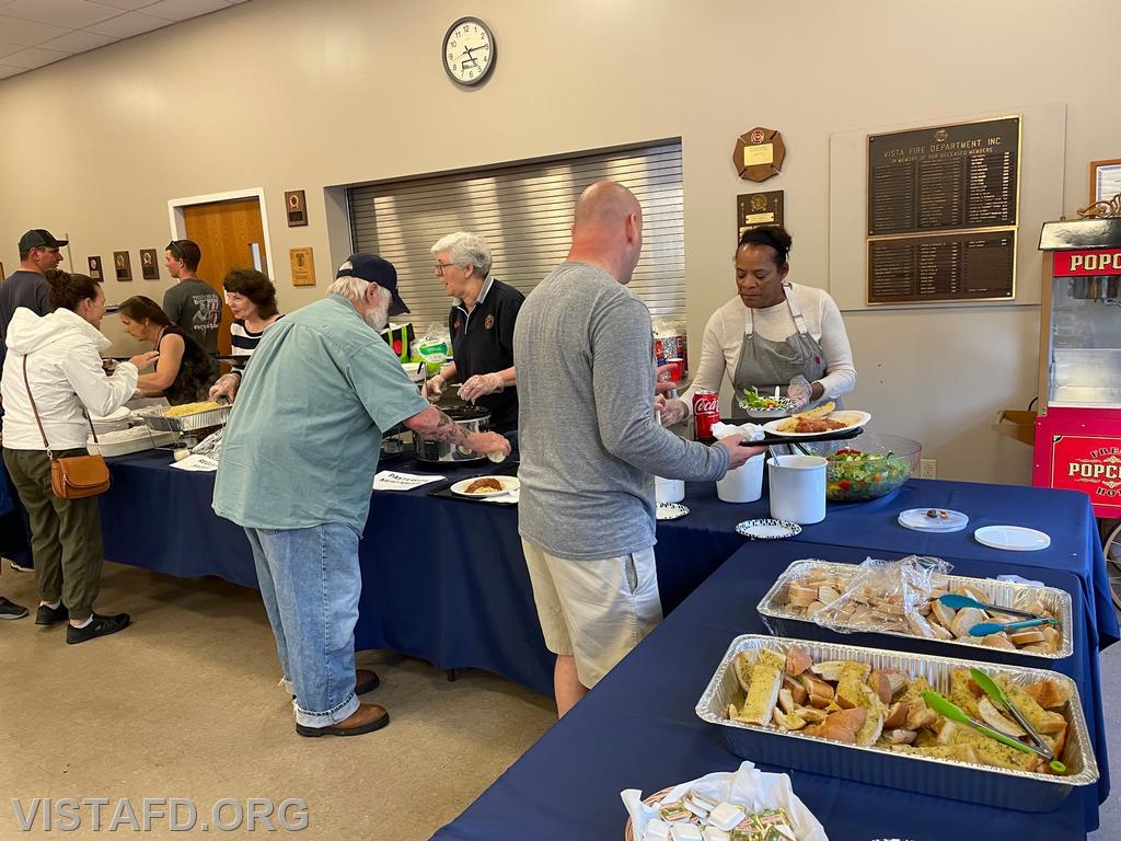 Members of the community picking up food during the "Spaghetti Night and Open House" event