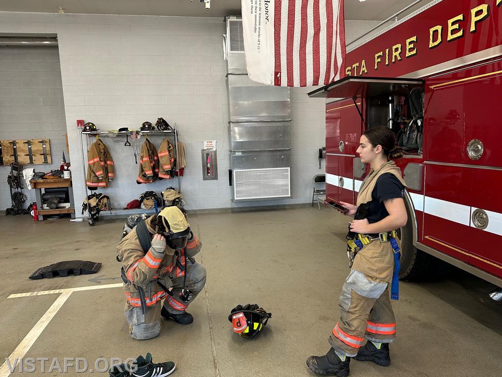Probationary Firefighter Franco Compagnone conducting a "2-minute drill" as Firefighter/EMT Kyla Whalen times him during "Firefighter Skills Class"