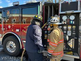Assistant Chief Mike Peck showing Firefighter/EMT Ryan Huntsman how to operate the Engine 141 pump panel