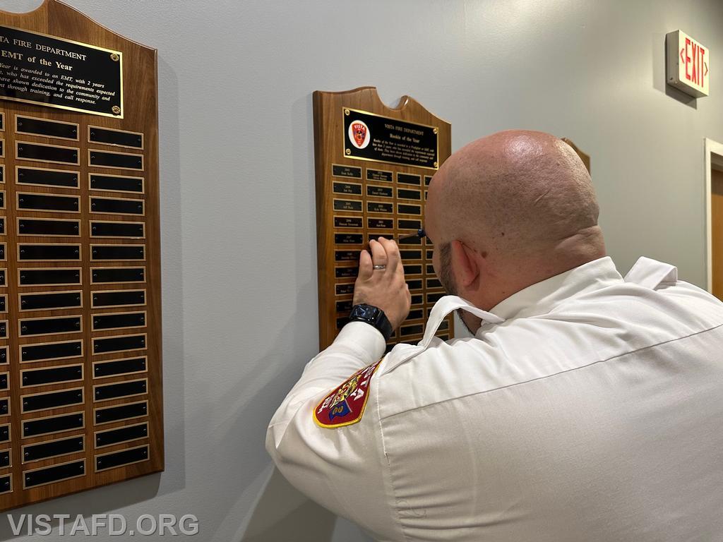 Firefighter/EMT Ryan Huntsman putting his name on the Vista Fire Department "Rookie of the Year" plaque