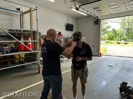 Captain Marc Baiocco going over the self-contained breathing apparatus (SCBA) with Probationary Firefighter Ashtin Rama