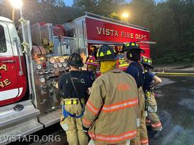 Lead Foreman Mike Peck going over the Engine 142 pump panel with Vista Firefighters