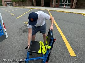 Probationary Firefighter Ty Graygor practices operating the stair chair