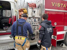Captain Marc Baiocco reviewing Engine 142 pump panel operations with Firefighter/EMT Ashtin Rama during driver training