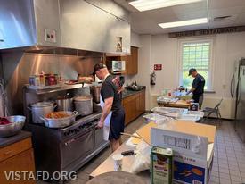 Captain Marc Baiocco and Firefighter Phil Katz preparing food during our Pasta Night event