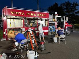 Firefighter Ron Egloff, Firefighter Phil Katz, and Lt. Dan Castelhano cleaning and detailing Engine 142 during Annual Dinner inspection preparations