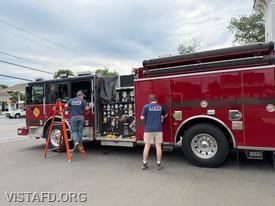 Foreman Pietro Cipriano and Firefighter Ty Graygor cleaning Engine 141 during preparations for the Annual Dinner