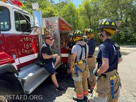 Captain Marc Baiocco provides hands-on pump operations training at the Engine 142 pump panel as part of the department's driver training program
