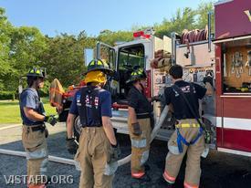 Foreman Brian Sferra reviewing the Engine 142 pump panel with Firefighter/EMT Ashtin Rama as Firefighter Phil Wanderman and Firefighter/EMT Andy Korman look on