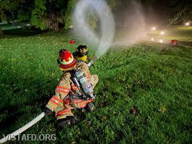 Vista Firefighters applying water to the simulated fire during the "Initial Structure Fire Tasks" drill